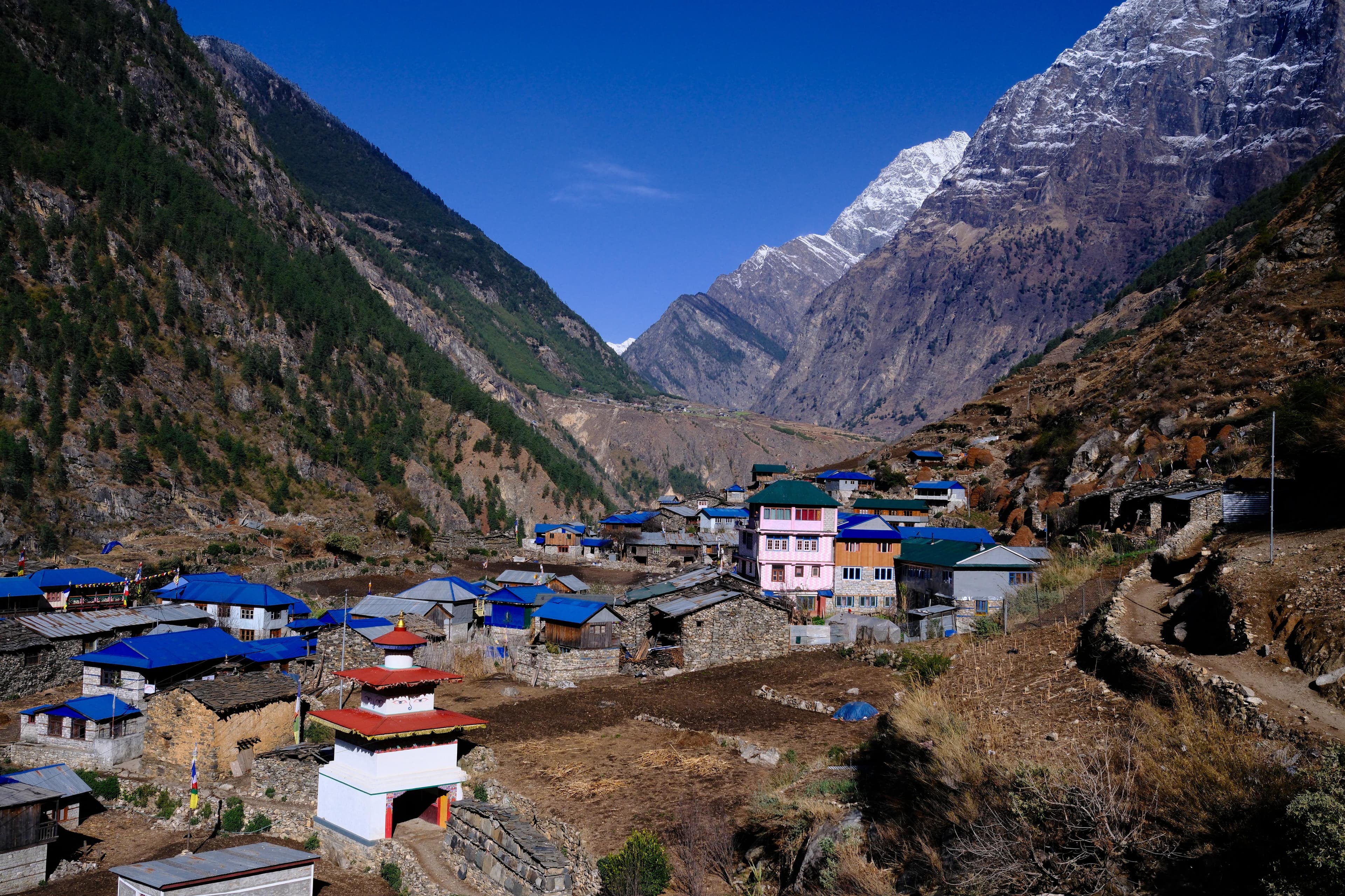 Manaslu trekking village with stupa nestled in a dramatic Himalayan valley