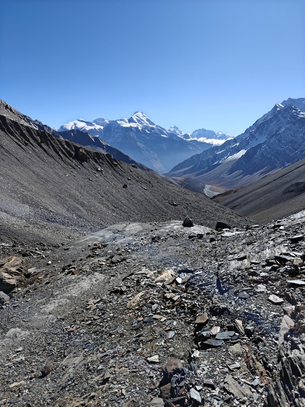 Trekking through barren Himalayan valley towards majestic snow-capped mountains
