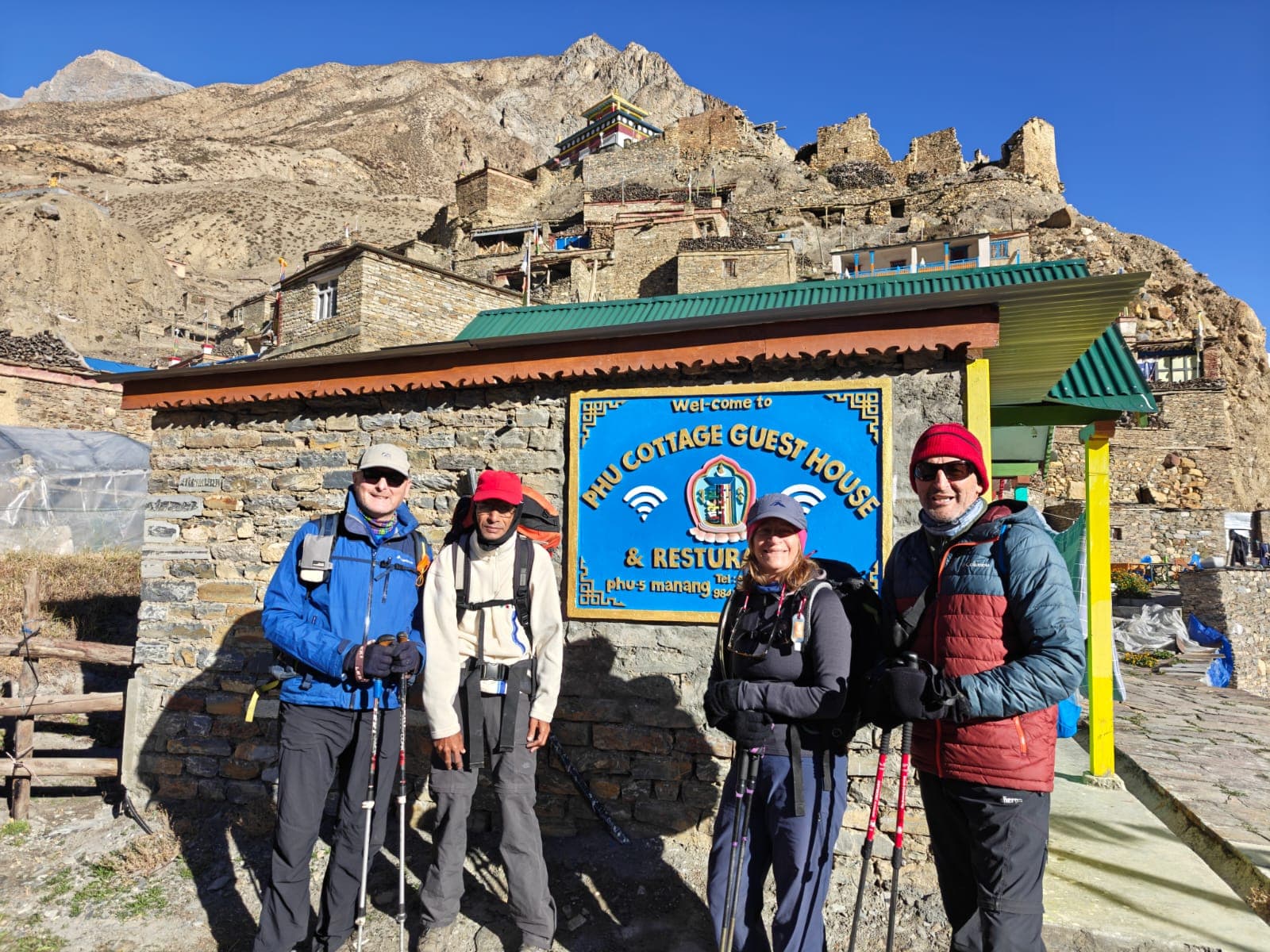 Four trekkers outside Phu Cottage Guesthouse in Phu village, Manang Himalayas